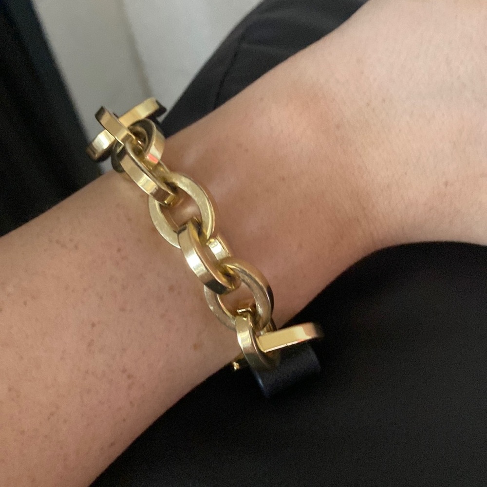 Gold and black bracelet it’s snaps on the wrist .